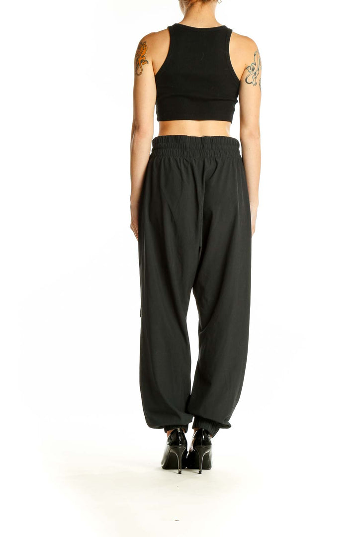 Side view of black Abercrombie & Fitch jogger pants on model with crop top