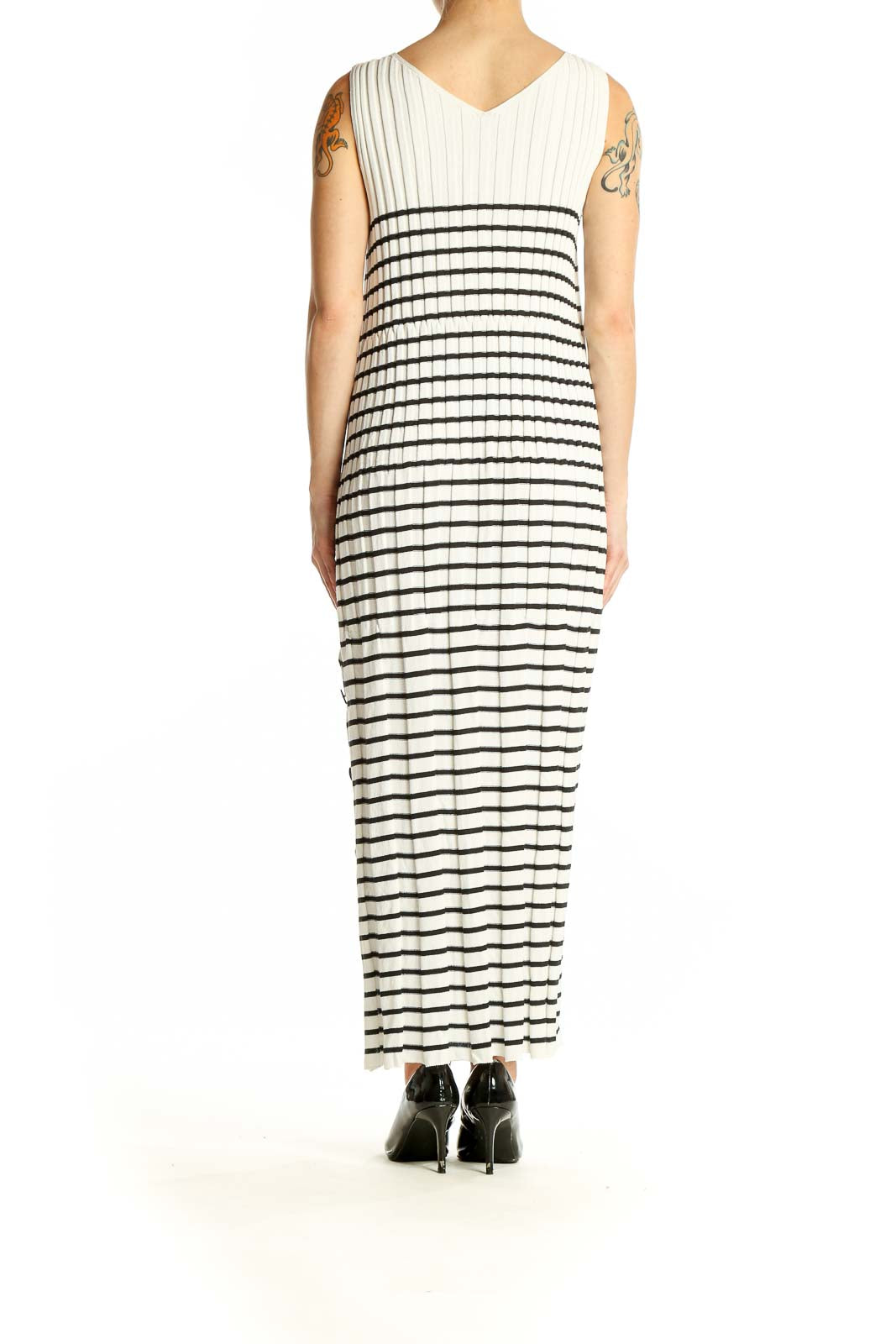 Side view of Qualite white and black striped maxi dress showing side slit