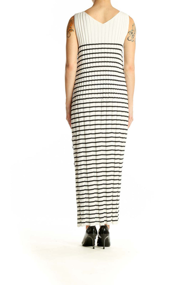 Side view of Qualite white and black striped maxi dress showing side slit