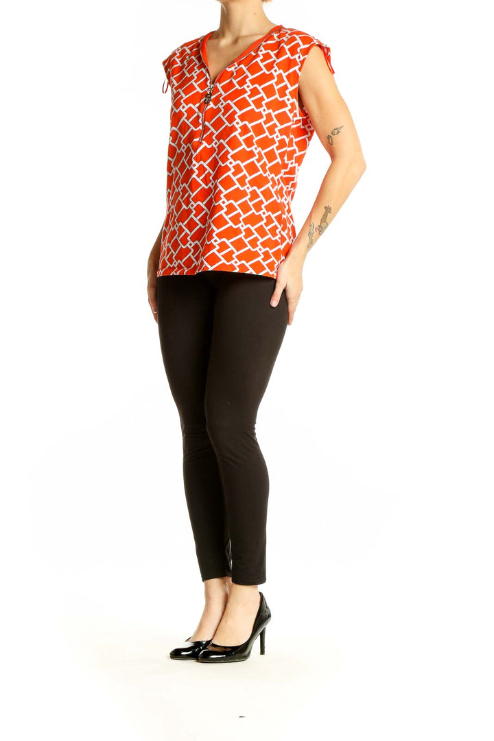 Front view of Michael Kors orange geometric print sleeveless top with V-neck and zipper detail