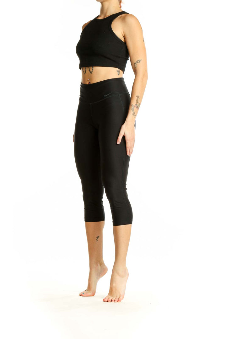 Front view of black Nike capri leggings on woman