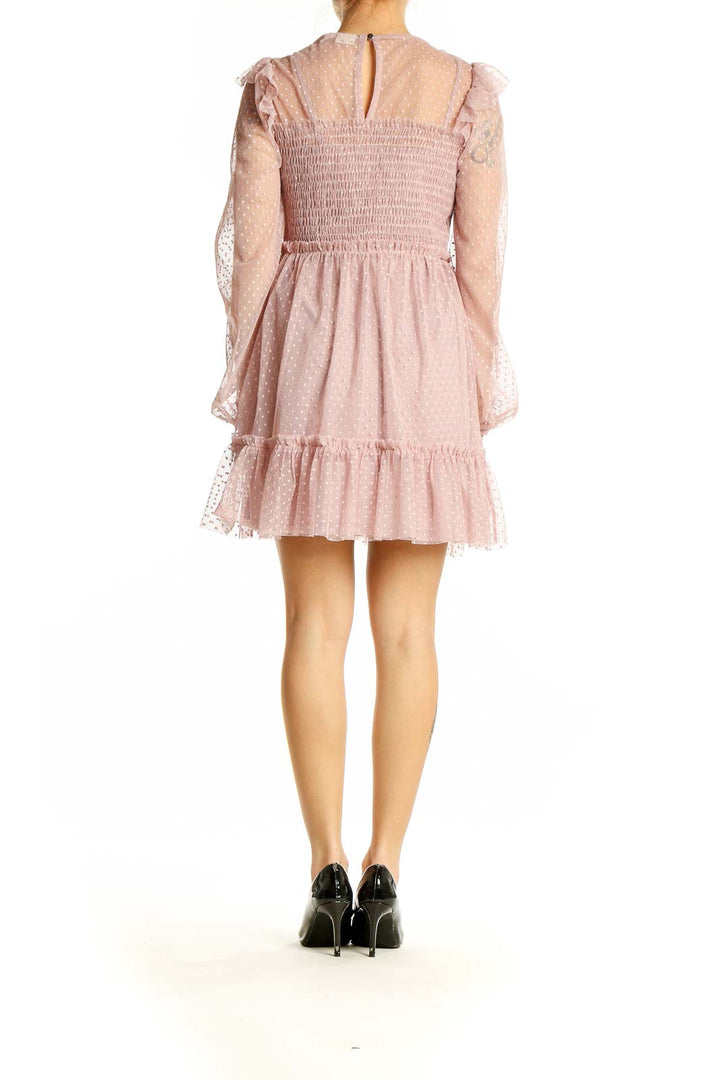 Back view of River Island pink polka dot mini dress showing ruffled hem and overall silhouette