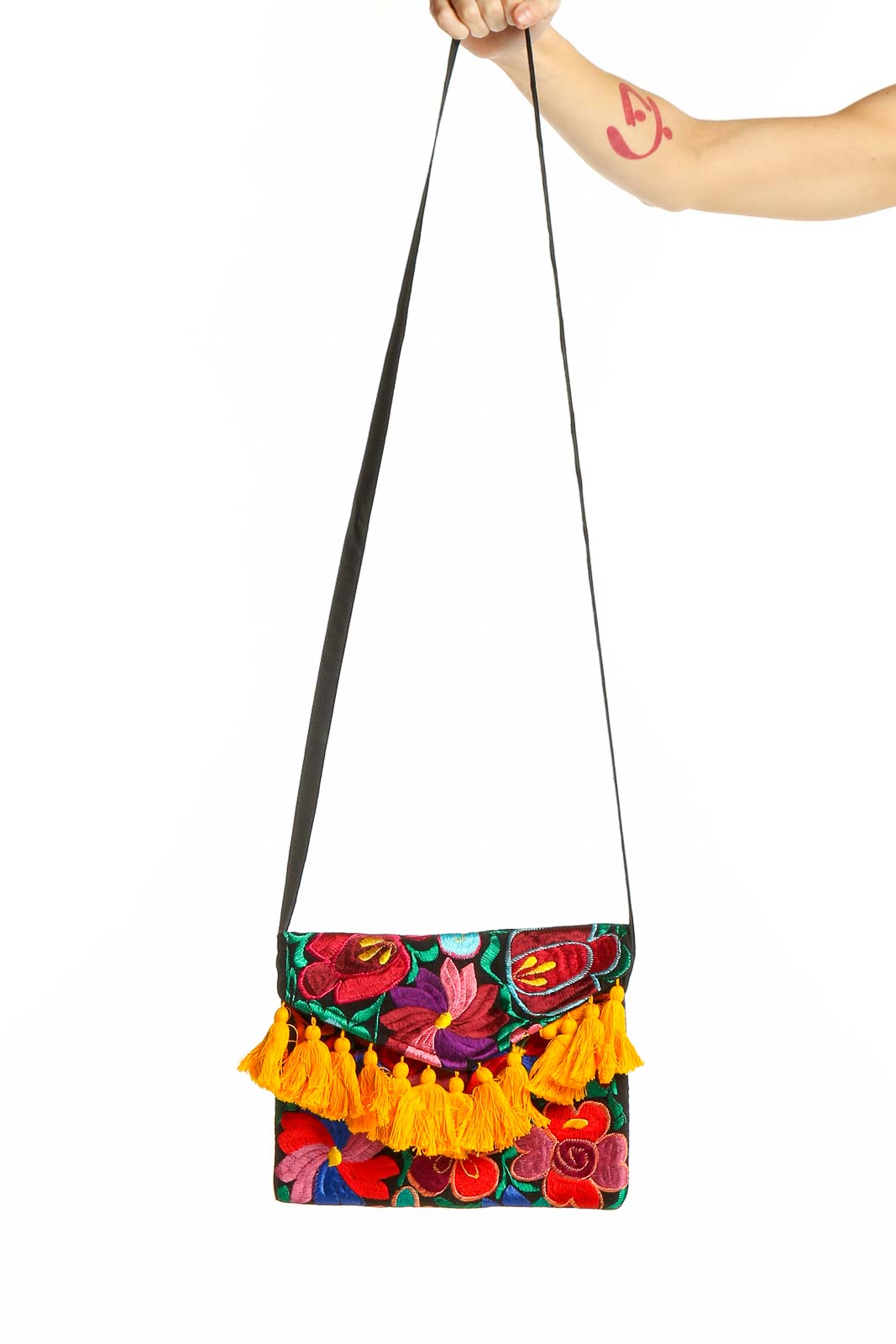 Front view of SilkRoll multicolor floral embroidered clutch with yellow tassels