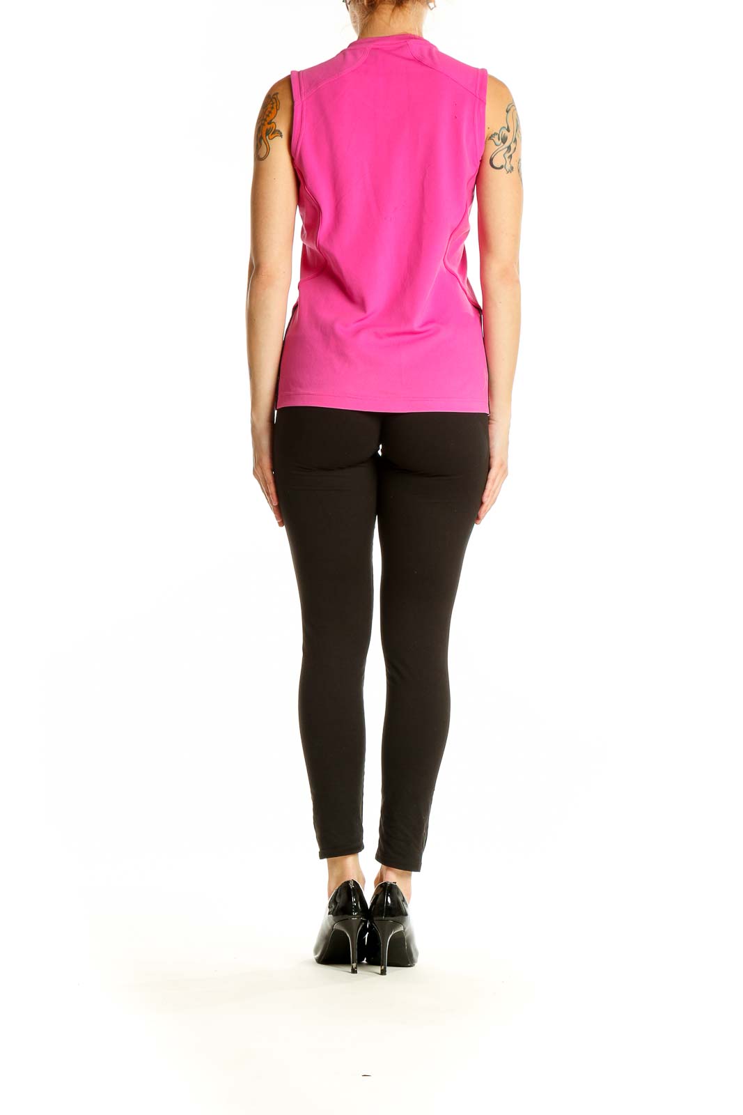 Side view of woman wearing pink Adidas sleeveless tank top with black leggings