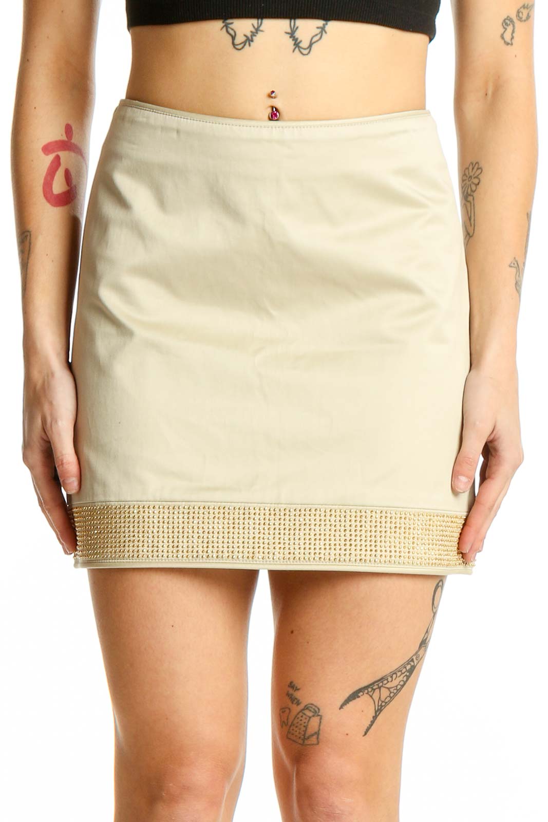 Front view of Burberry beige mini skirt with gold embellished hem