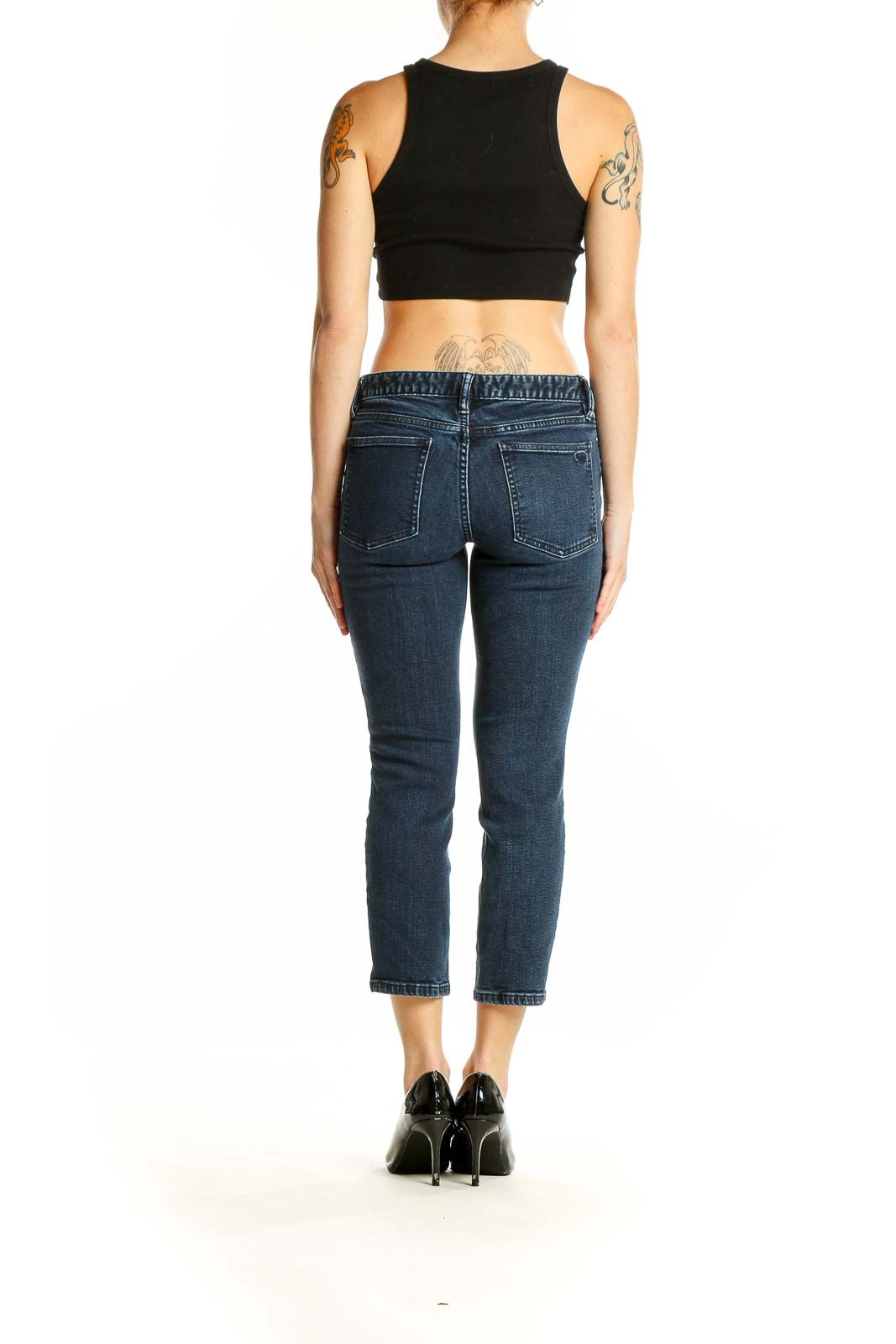 Back view of woman wearing Tory Burch dark blue cropped slim fit jeans