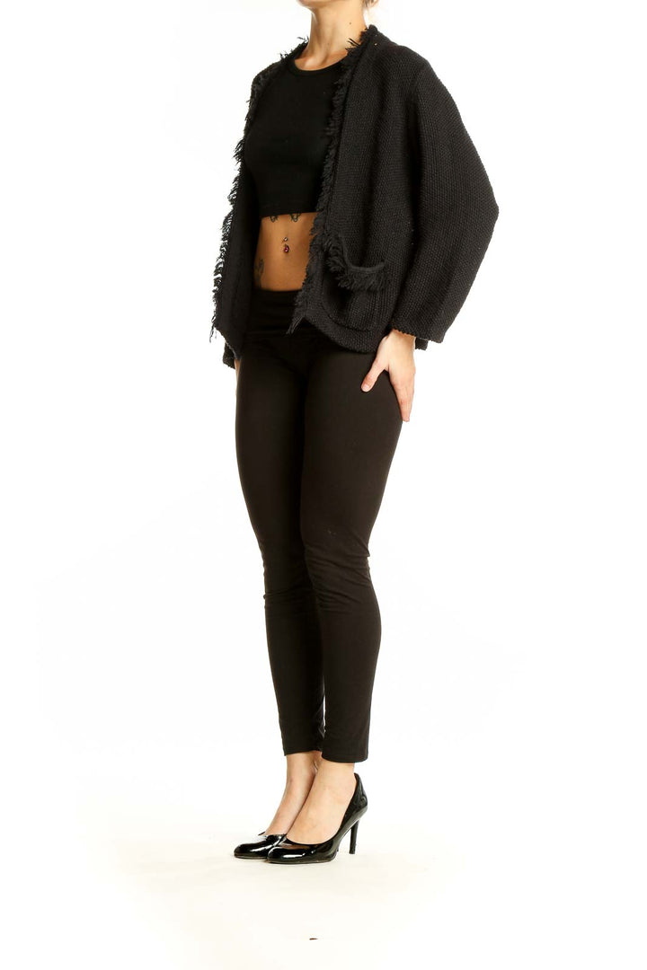 Front view of DKNY black open front cardigan with frayed edges