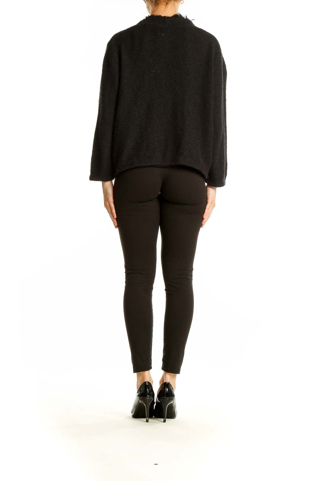 Side view of model wearing DKNY black open front cardigan with black outfit