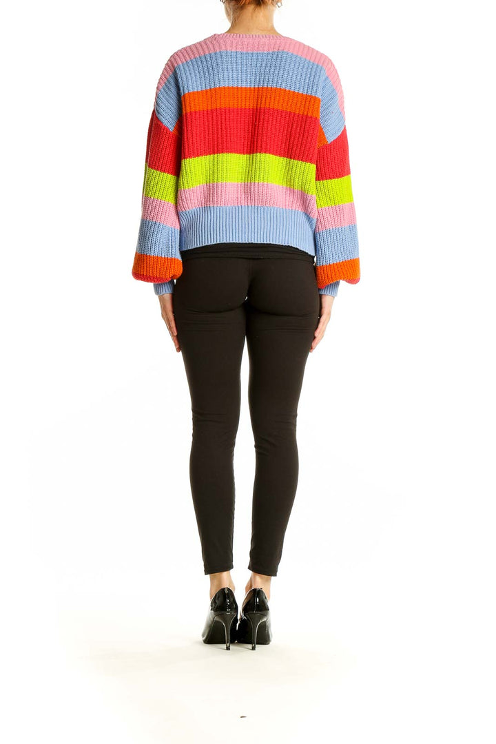 Side view of model wearing BROADWAY multicolor striped chunky knit sweater with black pants