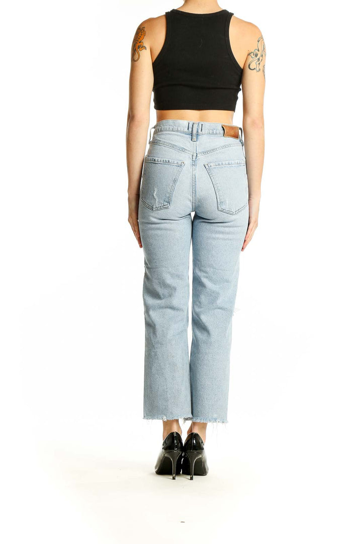 Back view of Citizens of Humanity light blue distressed straight leg jeans with black crop top