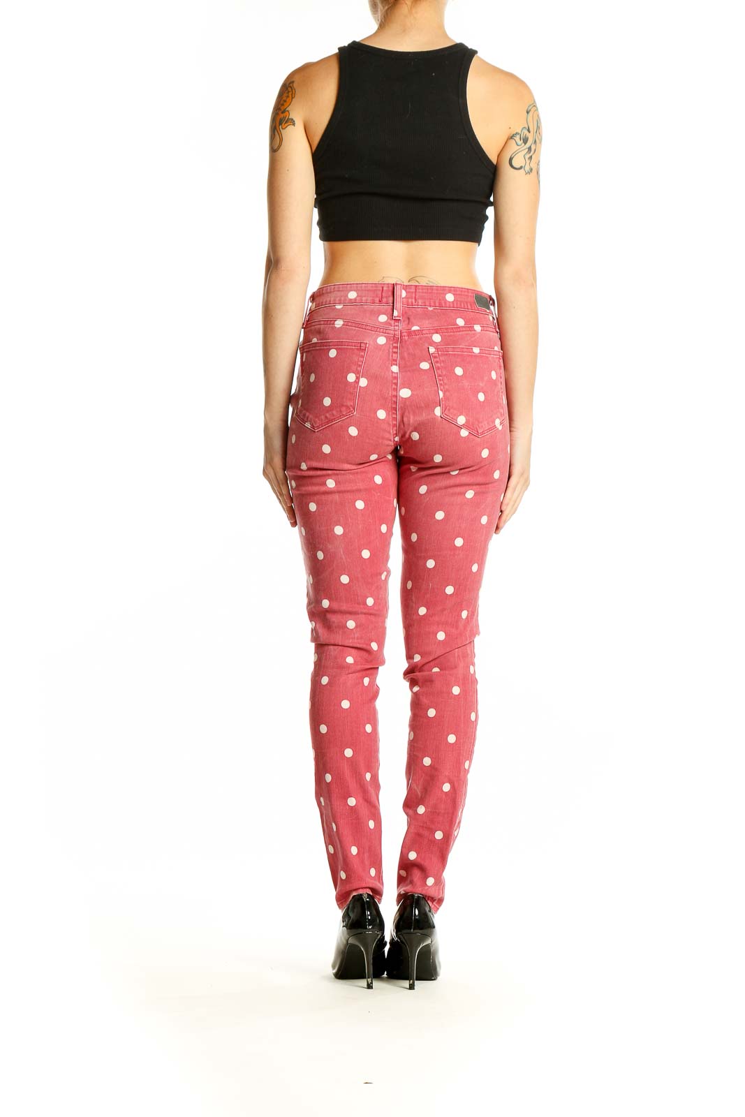 Back view of Paige pink polka dot skinny jeans on model with black crop top