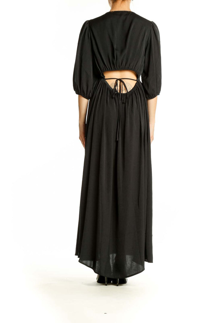 Side view of black Gap maxi dress showing flowing silhouette and balloon sleeves