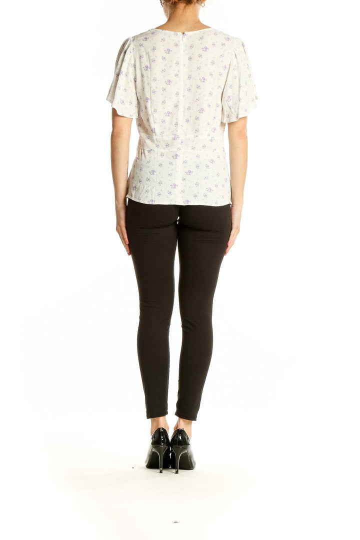 Side view of white LOFT blouse showing peplum-style hem and flutter sleeves