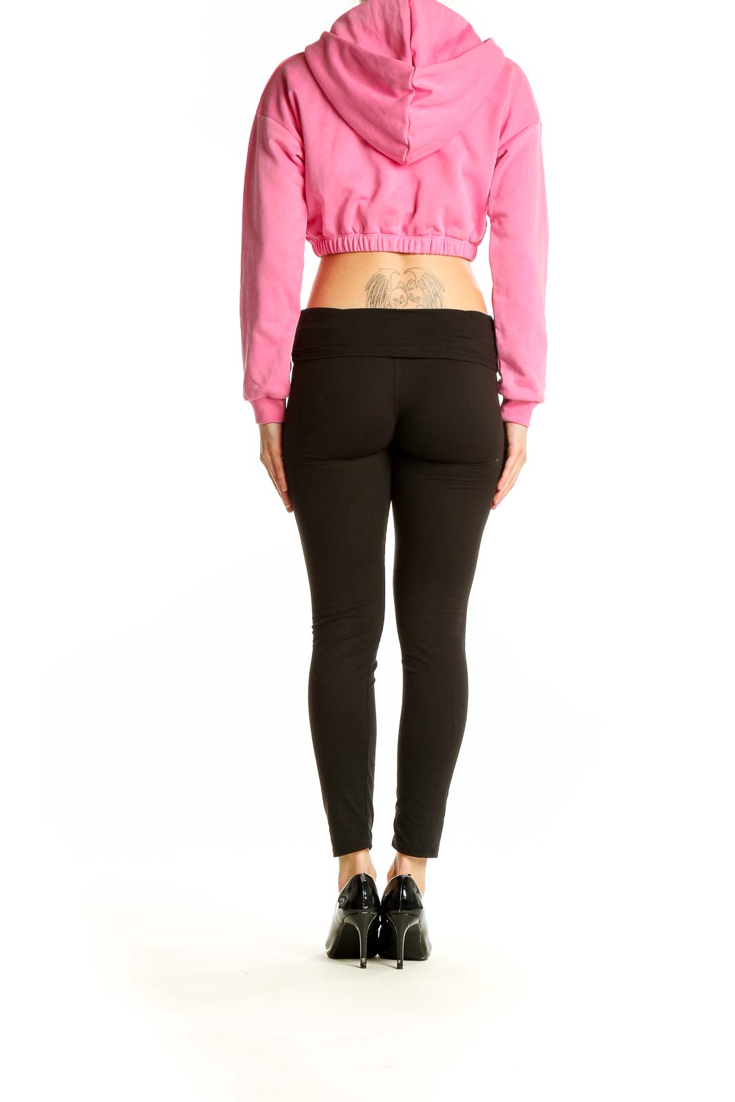 Back view of pink cropped hoodie from Naked Wardrobe with black leggings