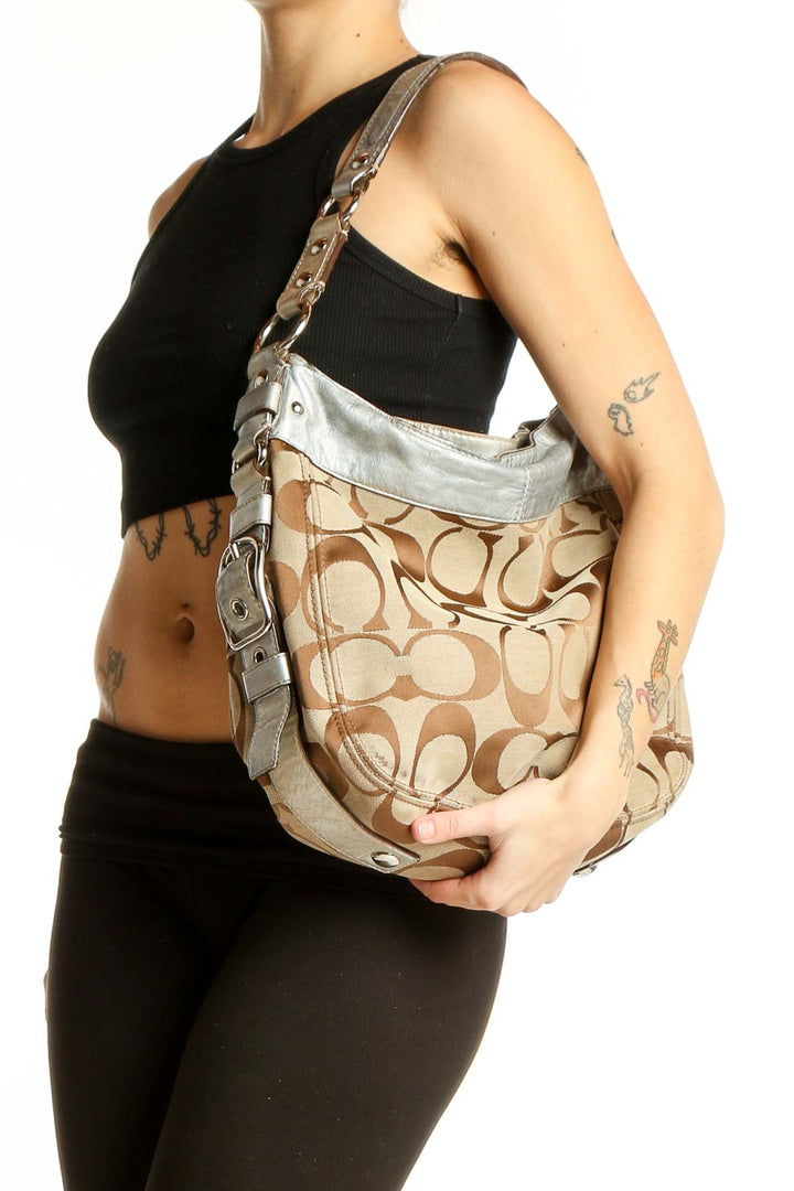 Front view of Coach Signature Print Hobo Bag in beige with silver accents