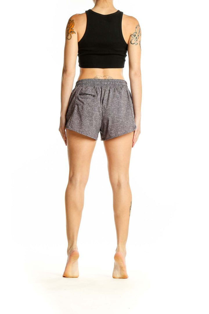 Side view of woman wearing gray Lululemon athletic shorts and black crop top