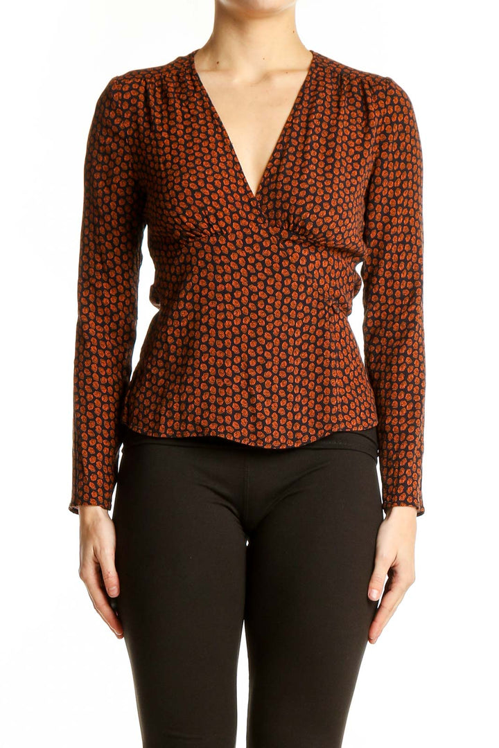 Front view of rust polka dot wrap top with V-neckline and peplum waist