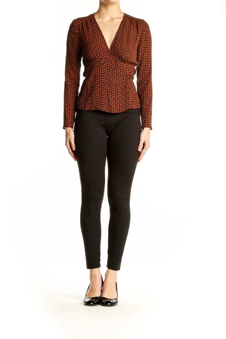 Front view of rust polka dot wrap top with V-neckline and peplum waist