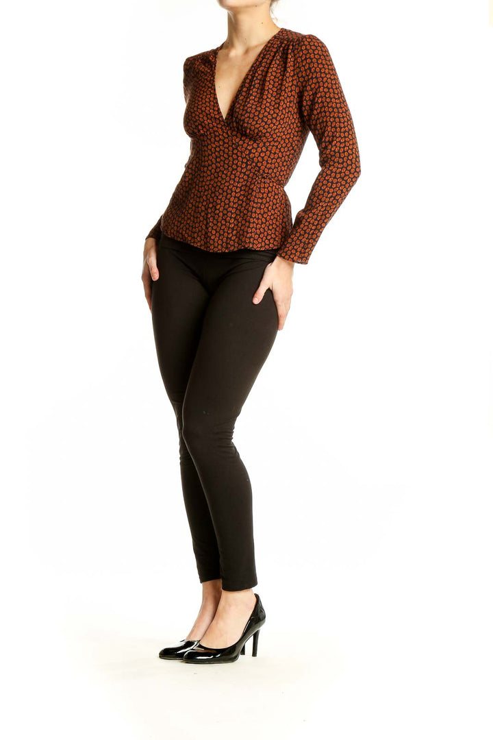 Front view of rust polka dot wrap top with V-neckline and peplum waist