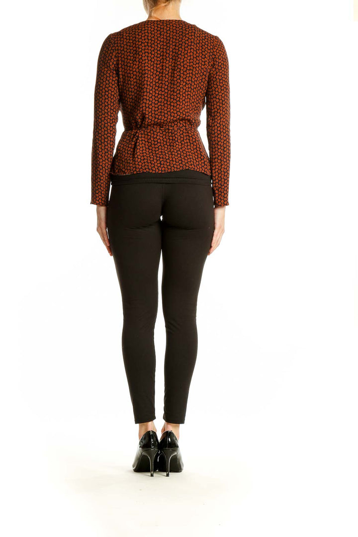 Back view of rust polka dot wrap top showing long sleeves and fitted silhouette