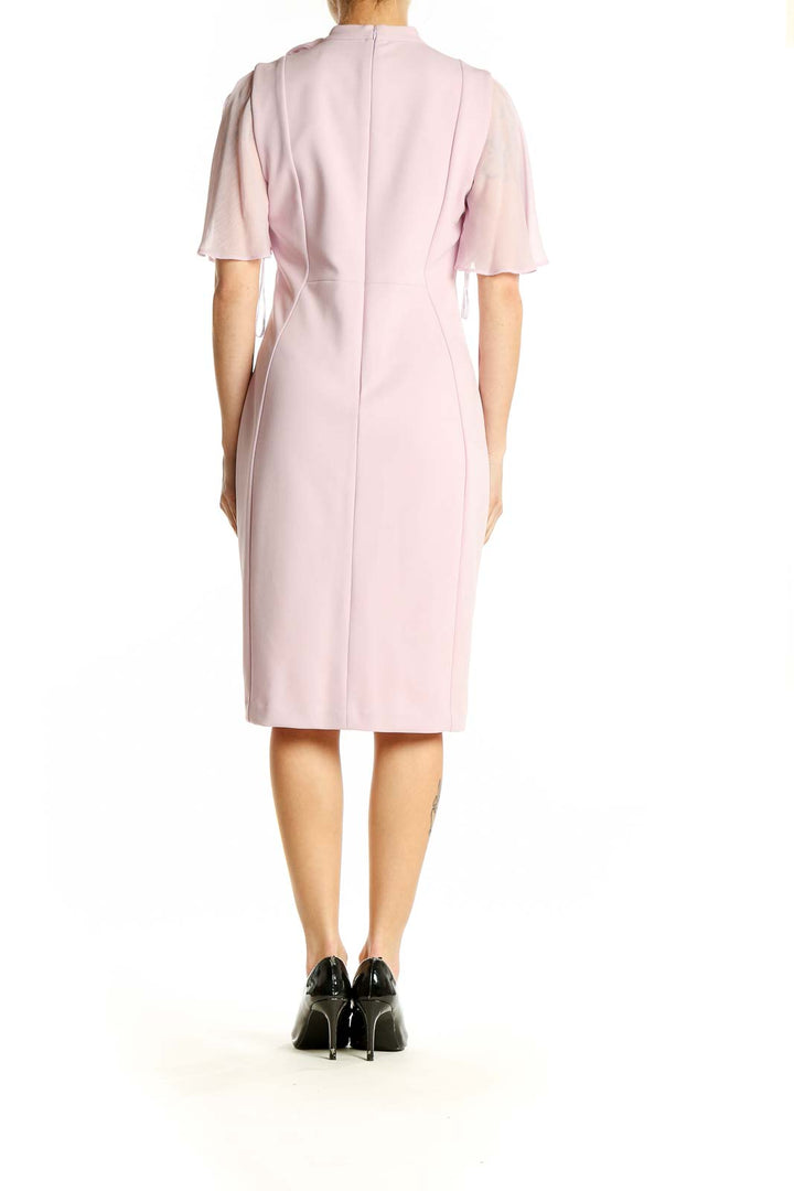 Side view of pink Calvin Klein sheath dress showing flutter sleeves and knee-length cut