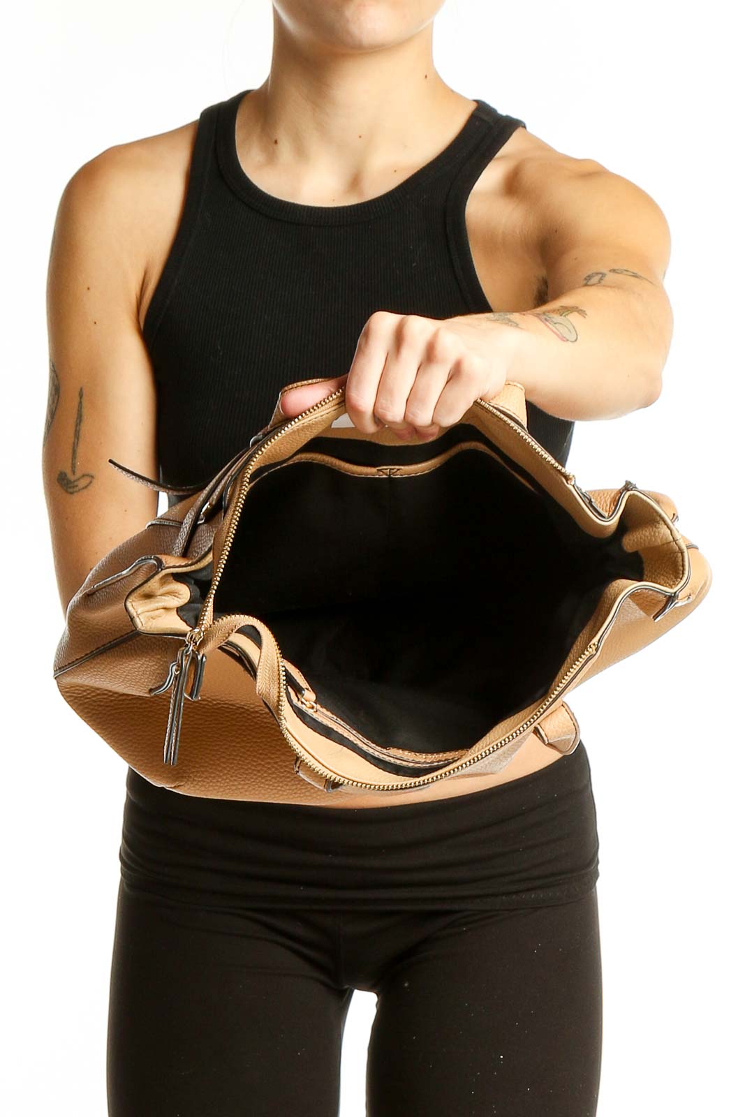 Side view of Nanette Lepore tan leather shoulder bag worn by model