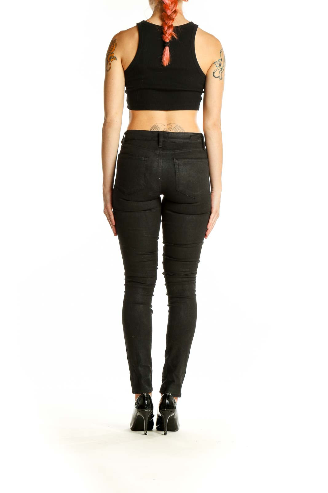 Back view of woman wearing black Paige skinny jeans and crop top