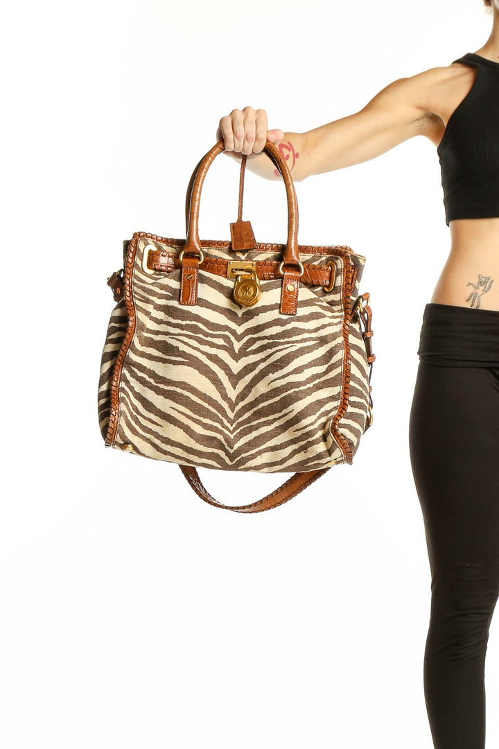 Front view of Michael Kors brown zebra print leather tote bag with cognac trim