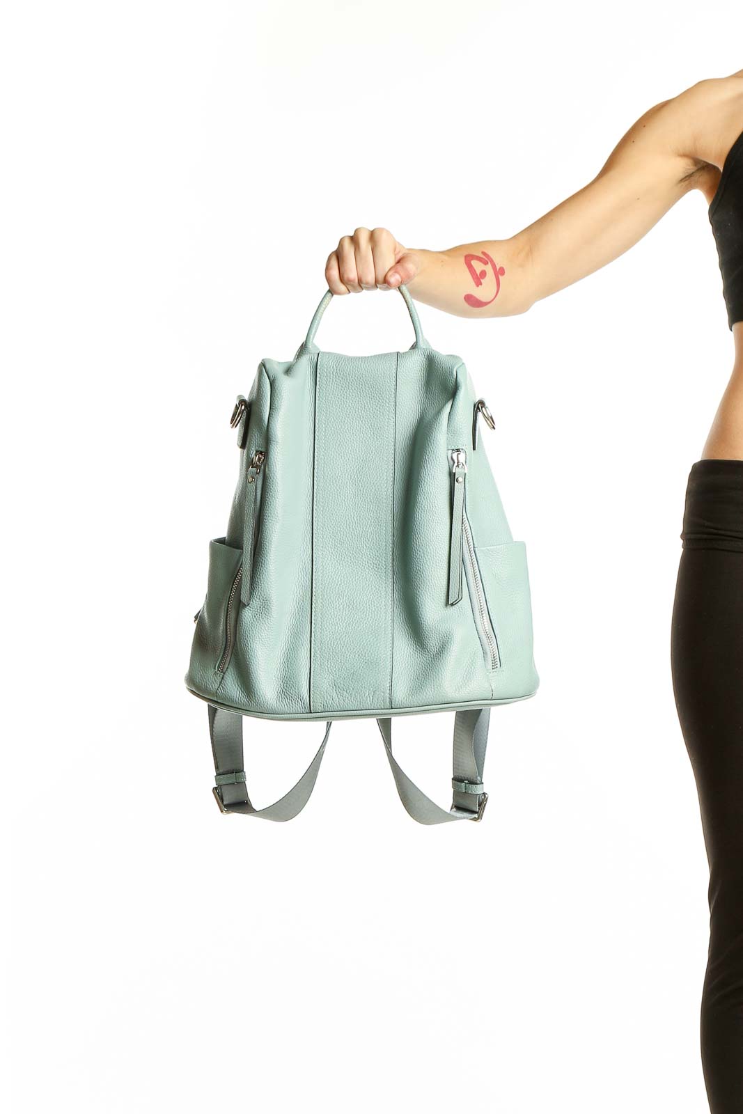 Front view of S-ZONE mint green leather convertible backpack held by model