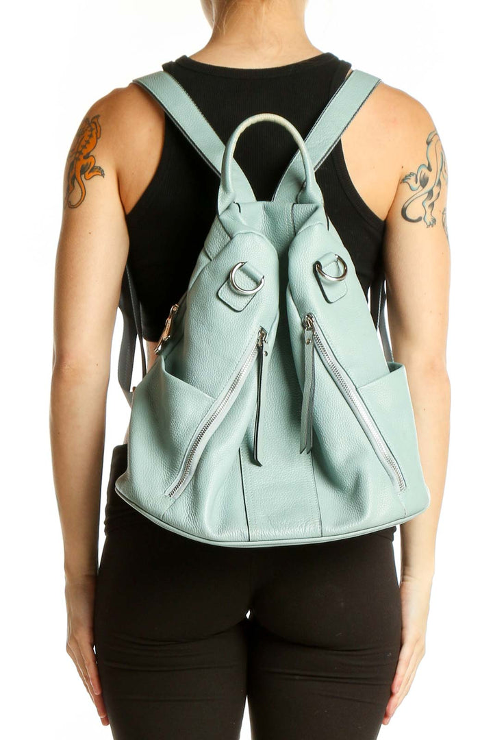 Front view of S-ZONE mint green leather convertible backpack held by model