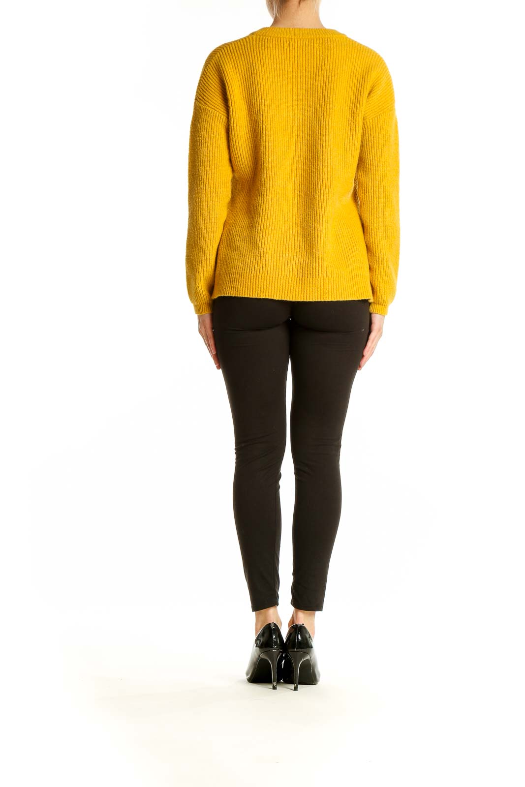 Side view of model wearing Harper Lane yellow V-neck ribbed knit sweater with black pants