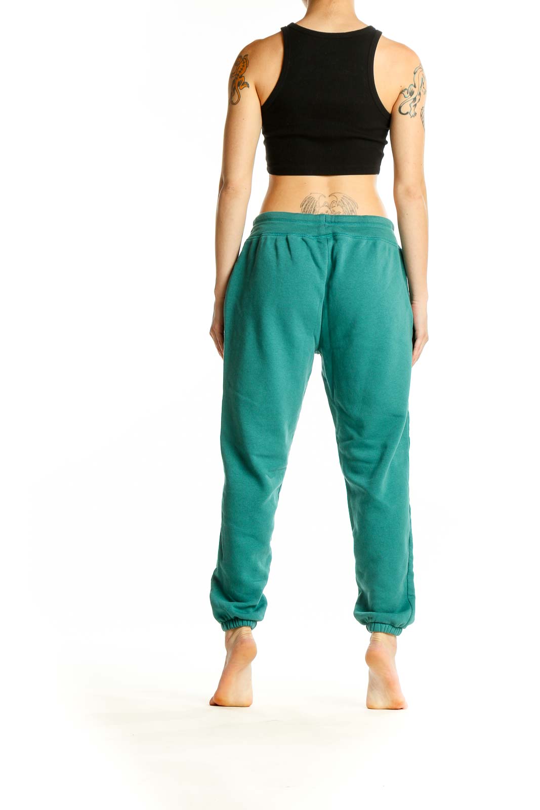 Side view of woman wearing teal Gap sweatpants with black crop top