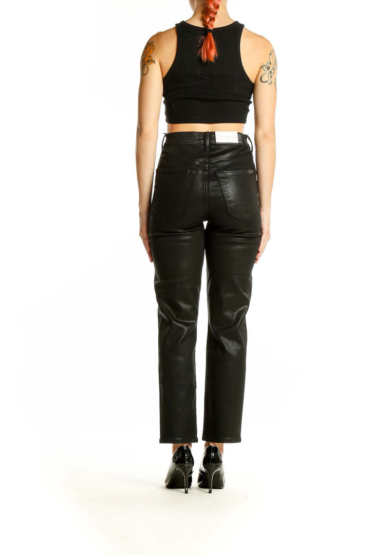 Side view of woman wearing 7 For All Mankind black coated high-rise straight leg jeans