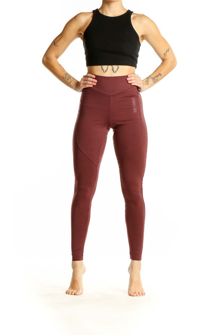 Front view of burgundy Gymshark high-waisted leggings on model