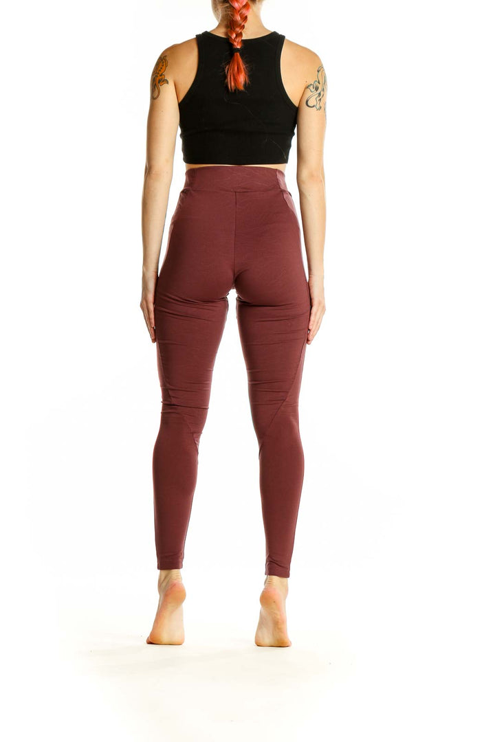 Side view of burgundy Gymshark high-waisted leggings with black crop top