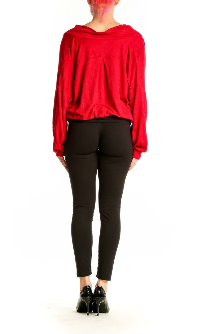 Side view of model wearing red wrap-style cropped hoodie with black pants