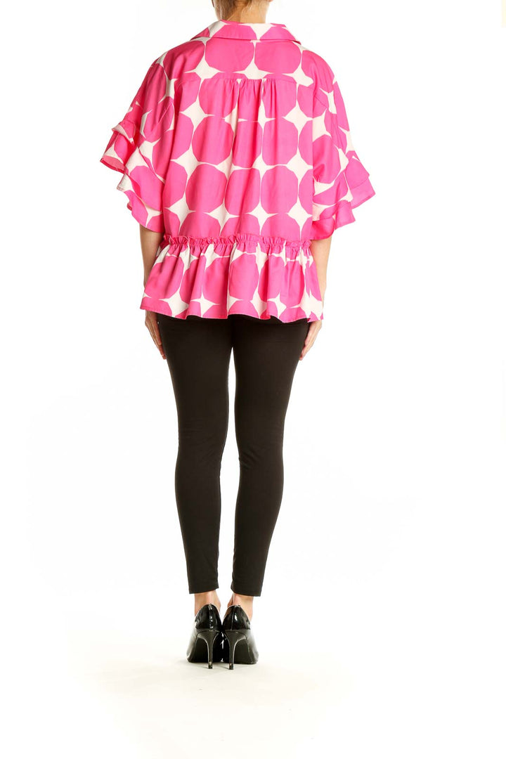 Side view of pink polka dot blouse showing peplum waist and ruffled sleeves