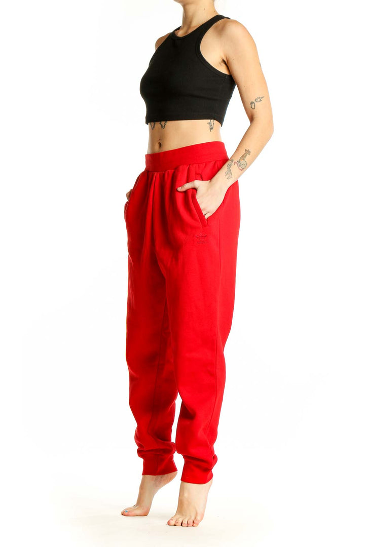 Front view of red Adidas cotton jogger sweatpants with elastic waistband