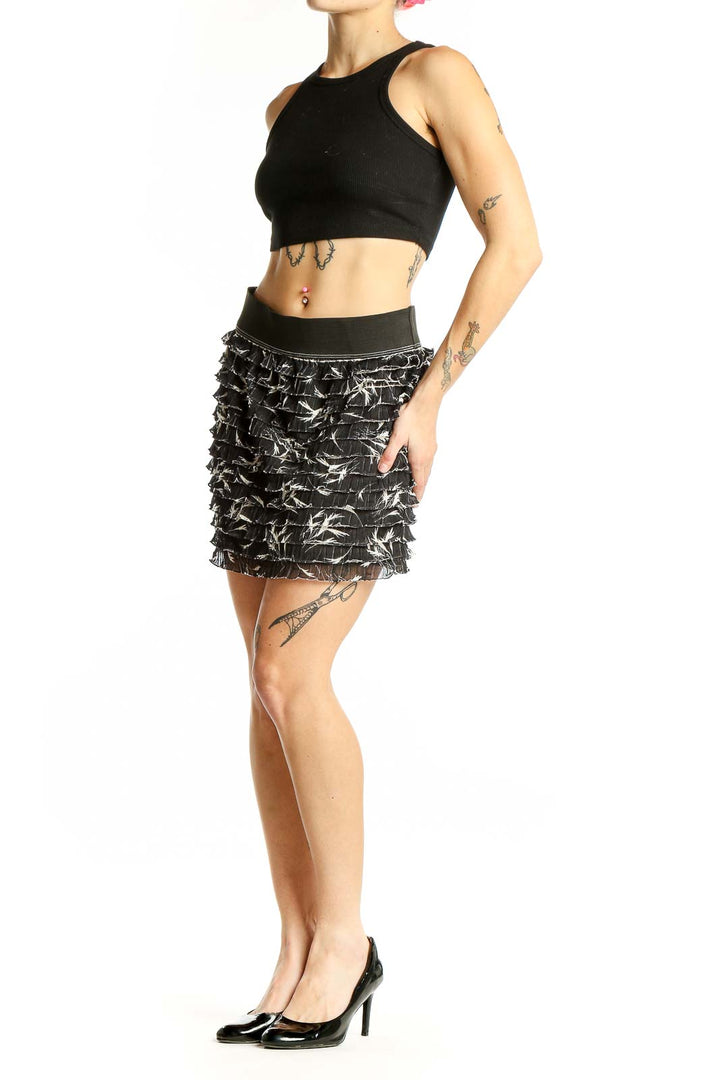 Front view of Free People black ruffled mini skirt with white abstract pattern