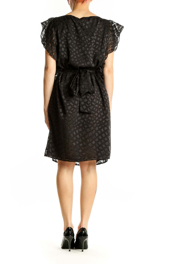 Side view of Michael Kors black geometric lace cocktail dress showing silhouette