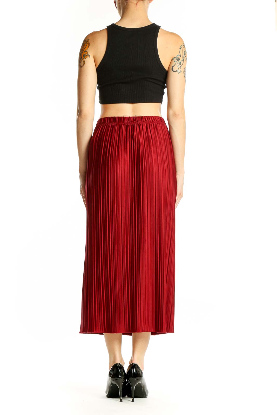 Side view of woman wearing red pleated midi skirt from Zara with black top