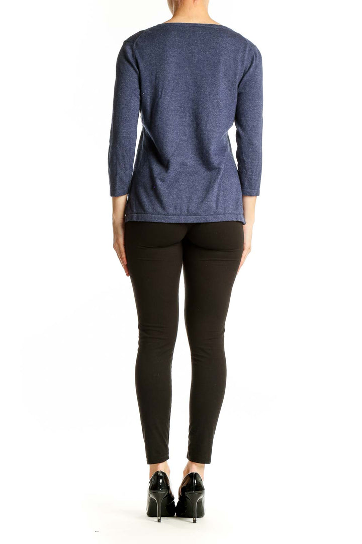 Side view of woman wearing Boden navy knit top with black pants