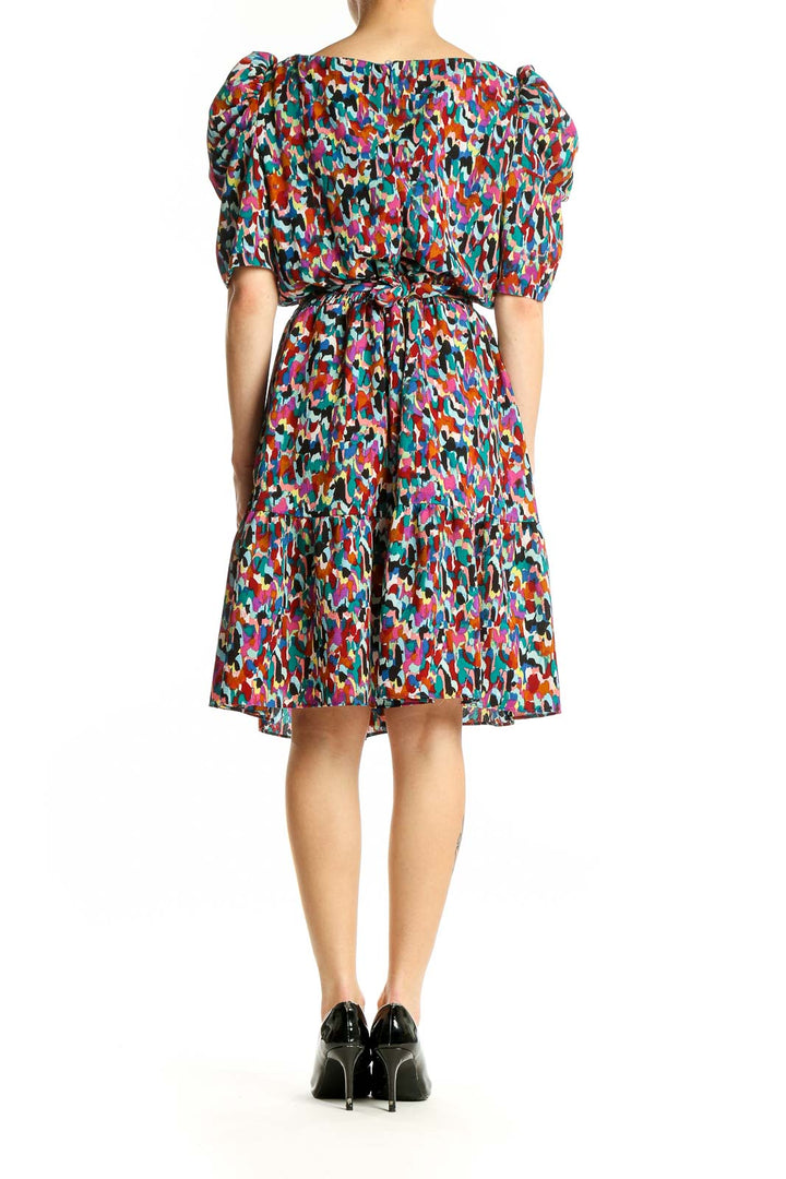 Side view of multicolor abstract print puff sleeve dress by London Times