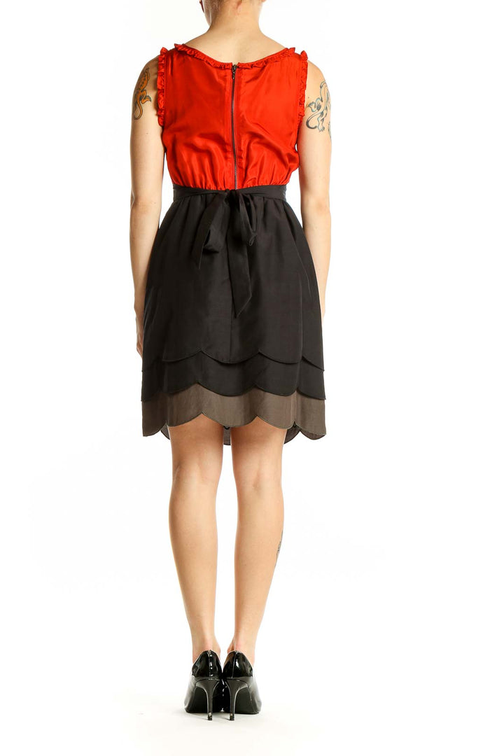 Side view of Maeve red silk dress showing ombre scalloped skirt detail
