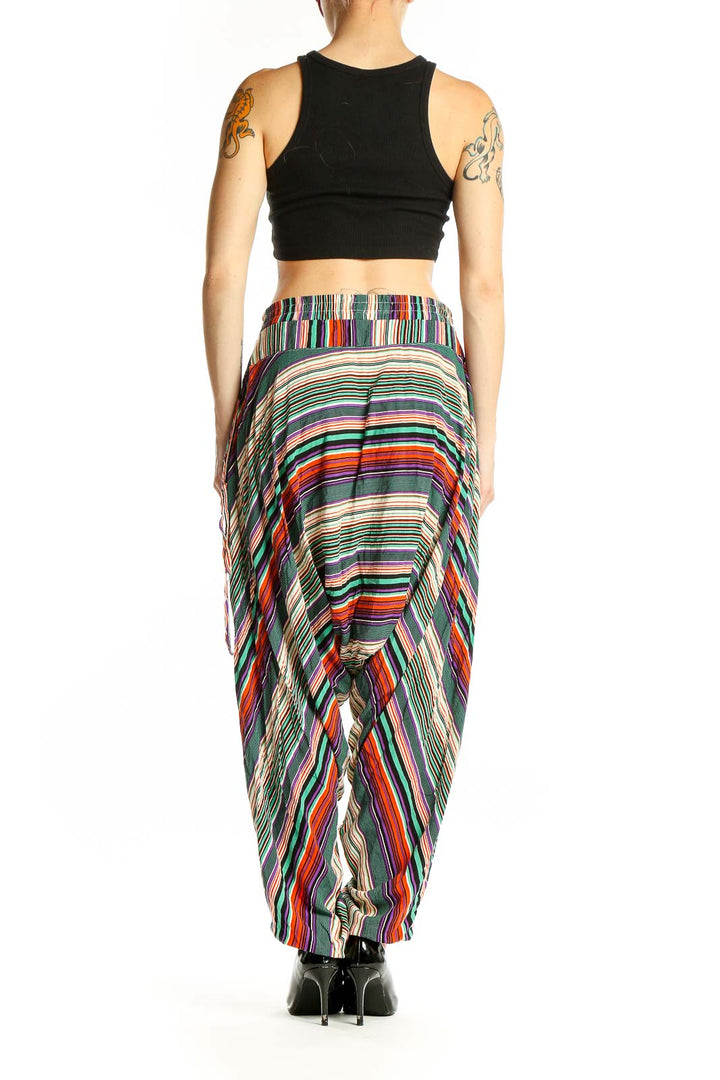 Side view of model wearing multicolor striped Buddha Pants with black crop top