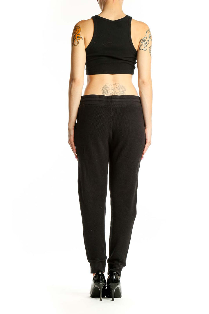 Side view of woman wearing black Splendid joggers and crop top