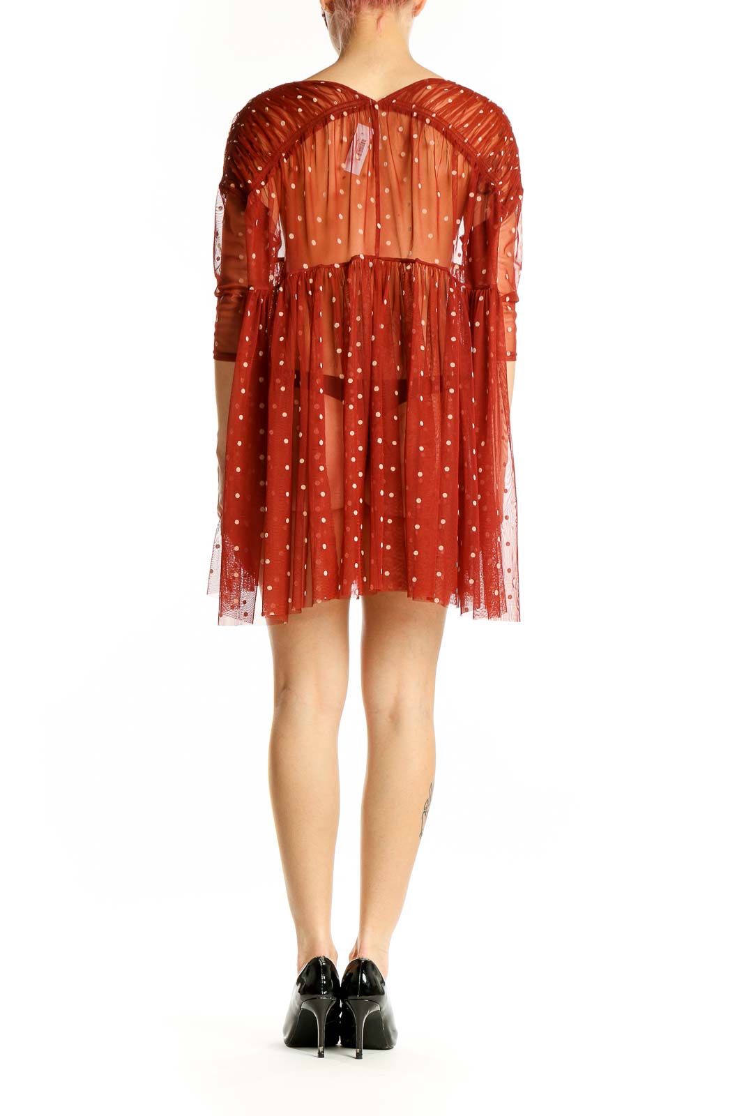 Side view of Free People rust polka dot sheer babydoll dress showing flowy skirt
