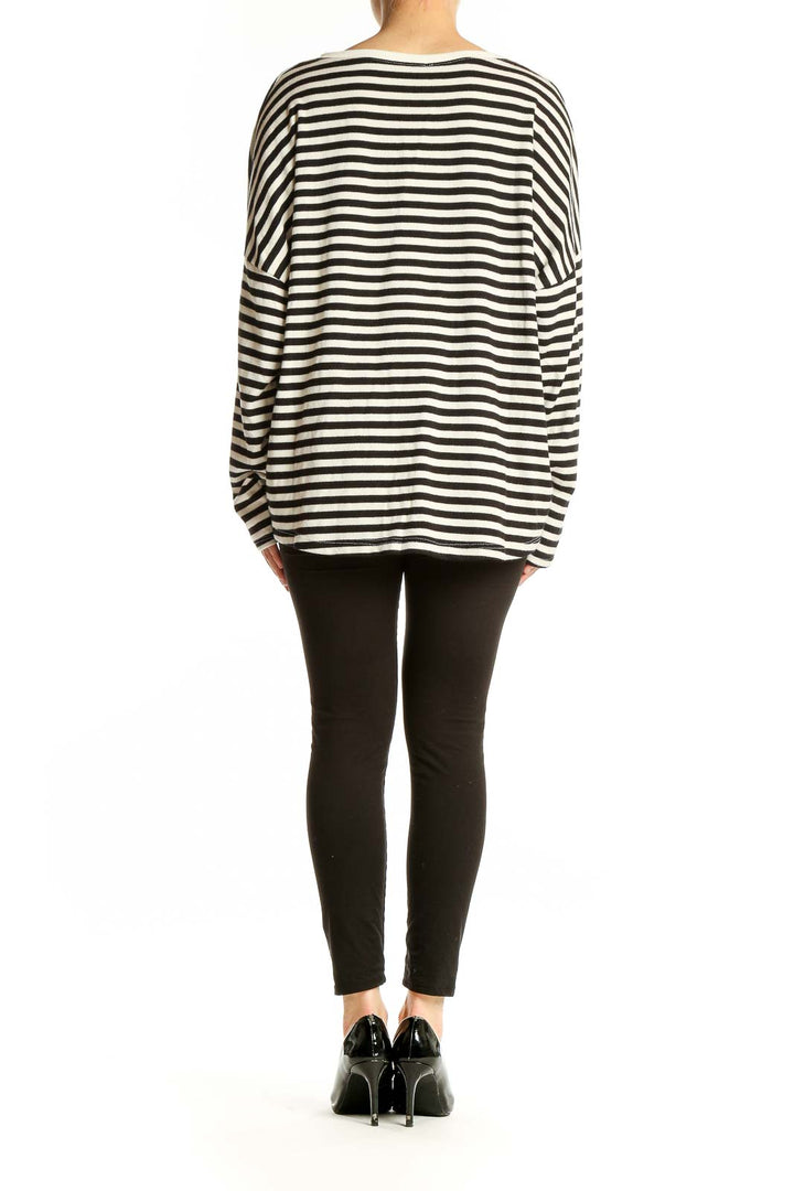 Side view of model wearing Venti6 black and white striped oversized top