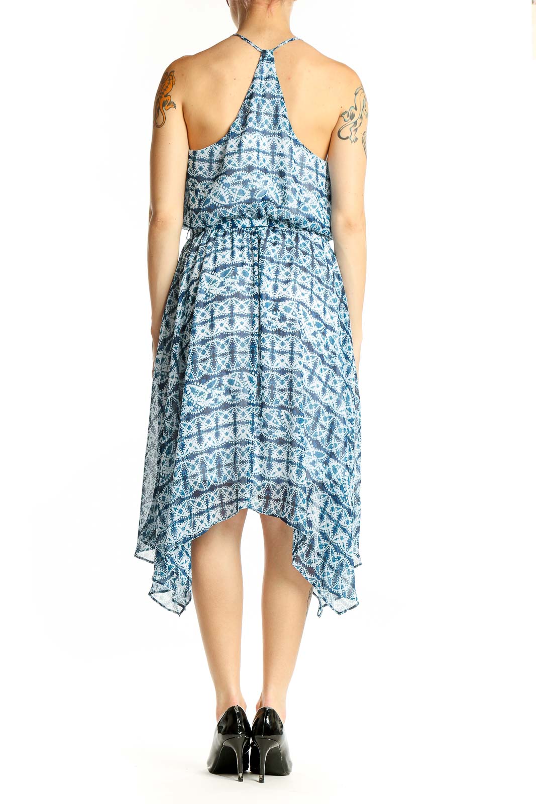 Back view of blue geometric print halter dress showing handkerchief hem