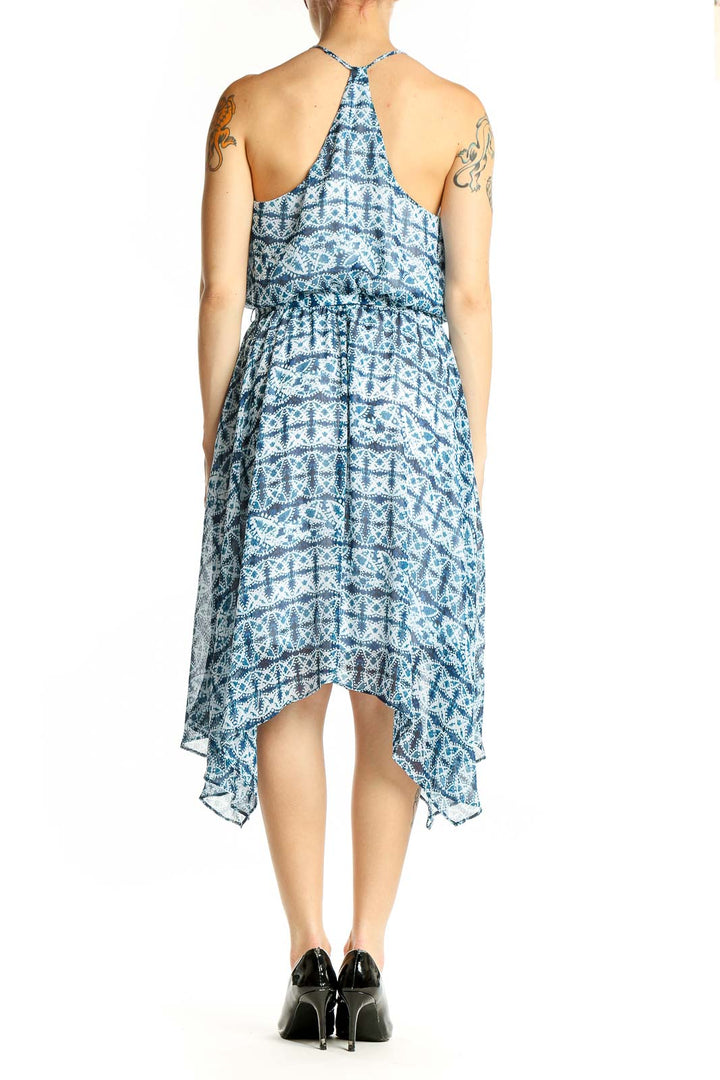 Back view of blue geometric print halter dress showing handkerchief hem